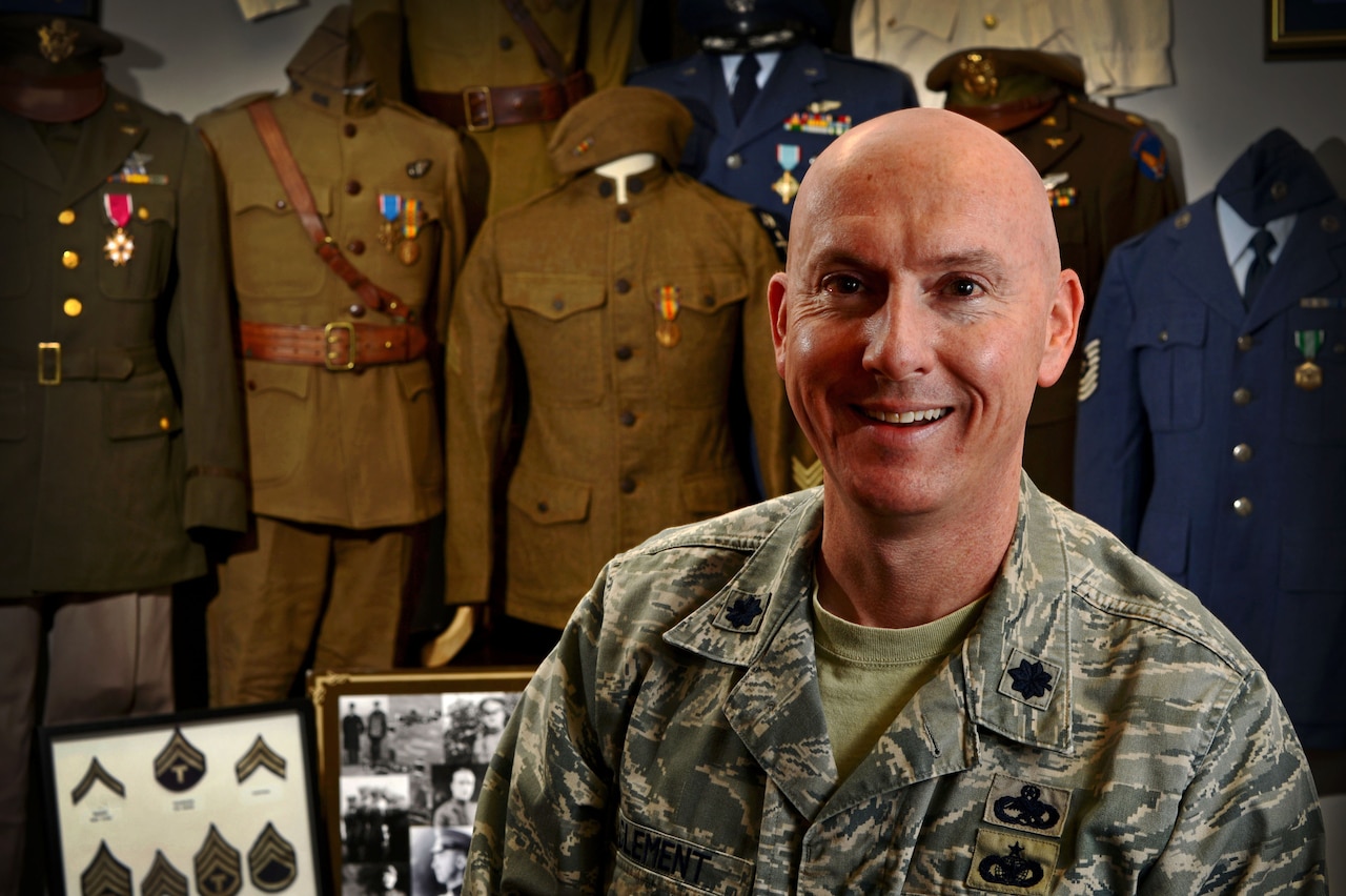 Air Force Lt. Col. Kyle Clement, 20th Maintenance Group deputy commander, stands in front of his vintage U.S. military uniform collection at Shaw Air Force Base, S.C., Jan. 9, 2015. U.S. Air Force photo by Senior Airman Jensen Stidham