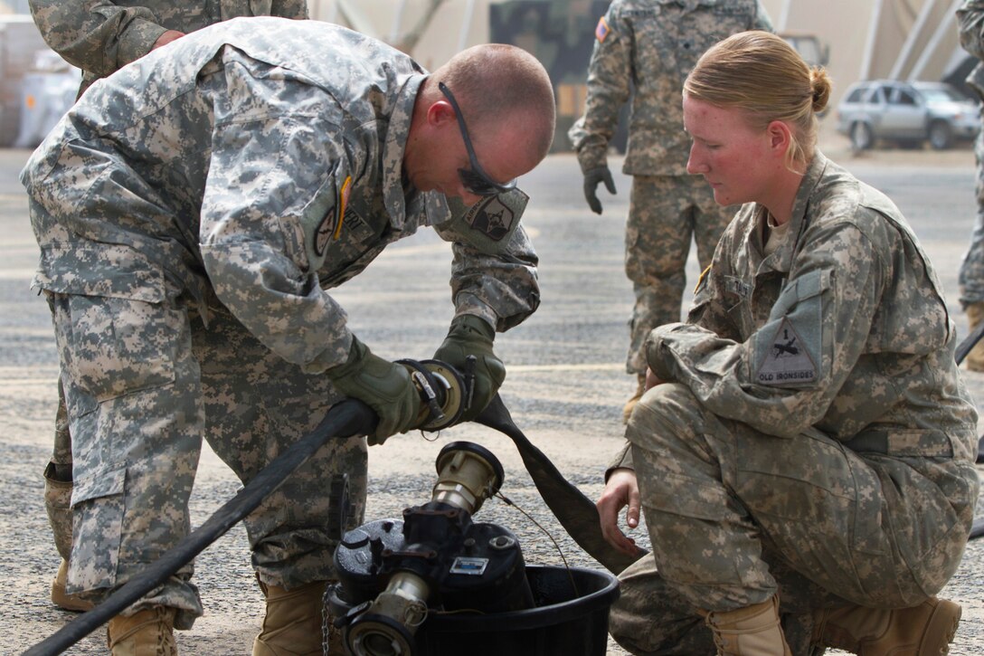 U.S. Army Spc. Danielle Taylor, right, teaches U.S. Army Sgt. Jarred