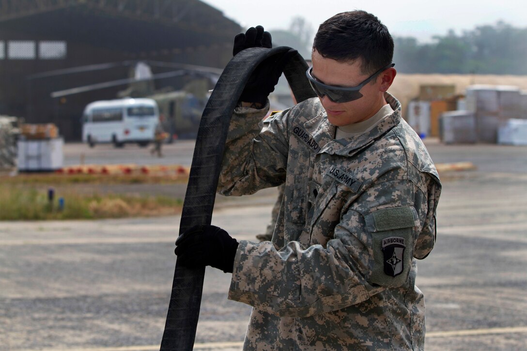U.S. Army Spc. Jose Guardado trains on how to drain a fuel hose during a fuel handlers class on Roberts International Airport outside of Monrovia, Liberia, Jan. 15, 2014. Guardado is a fuel handler assigned to the 101st Sustainment Brigade, Task Force Lifeliners, Joint Forces Command - United Assistance.