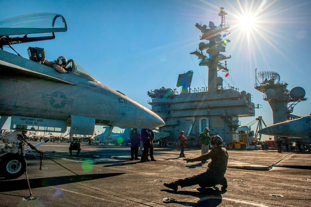 U.S. Navy Seaman Kevin Garges, foreground, conducts engine startups for an F/A-18E Super Hornet aircraft on the flight deck of the aircraft carrier USS Carl Vinson as the ship conducts flight operations in the U.S. 5th Fleet area of operations, Jan. 15, 2015. Garges is an aviation ordnanceman assigned to the Strike Fighter Squadron 81.