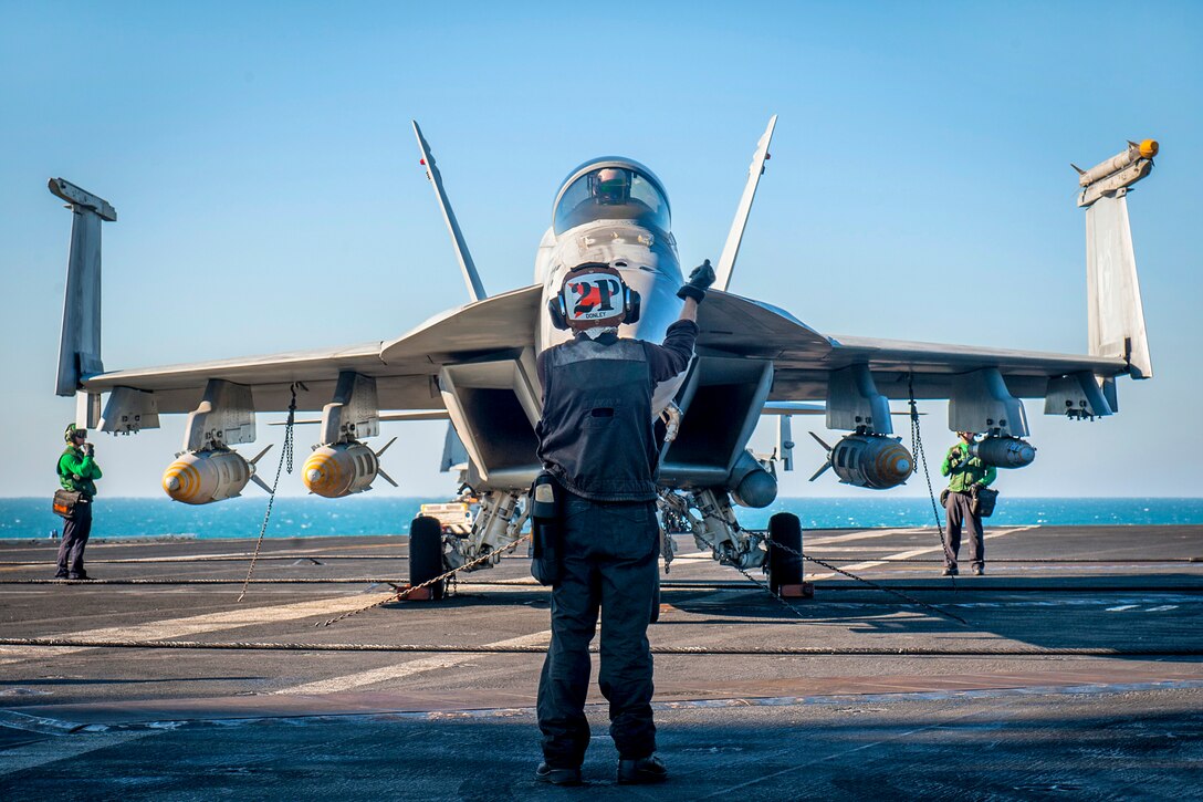 U.S. Navy Seaman Dylan Donley conducts engine startups for an F/A-18E Super Hornet aircraft on the flight deck of the aircraft carrier USS Carl Vinson as the ship conducts flight operations in the U.S. 5th Fleet area of operations, Jan. 14, 2015. Donely is an airman assigned to the Strike Fighter Squadron 81.