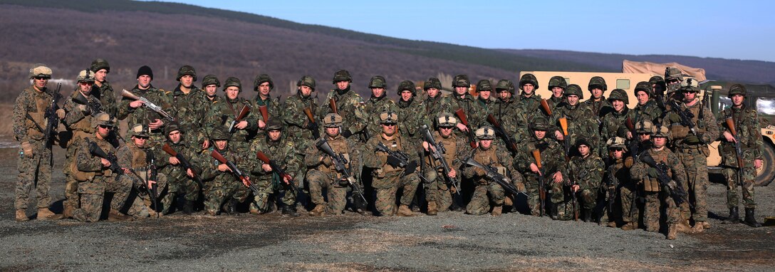 Bulgarian soldiers and Black Sea Rotational Force Marines pose together after the successful completion of a weapons familiarization range Jan. 13 at Novo Selo Training Area, Bulgaria. The Bulgarian Soldiers and BSRF Marines traded rifles to practice with them for the duration of the range. (U.S. Marine Corps photo by Cpl. Ryan Young/released)