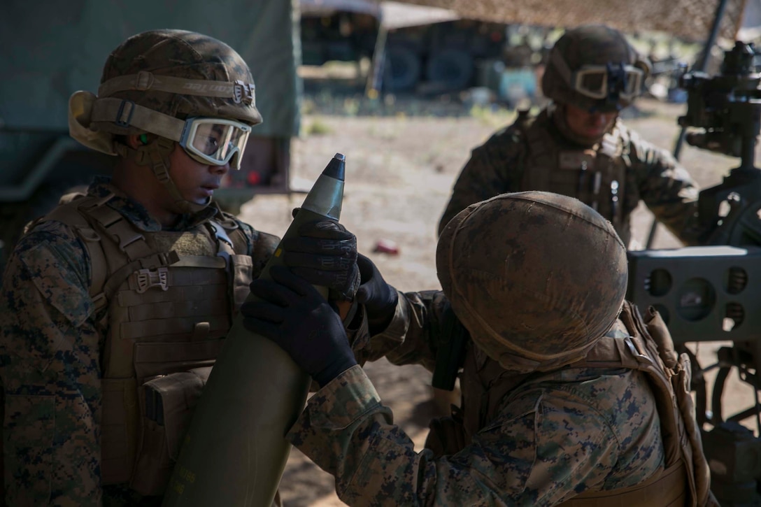 Pfc. Xhindly Villanueva, left, holds a round while Sgt. Roland Gonzales makes sure the timer on the fuse is set to the correct distance Jan. 12 during exercise Lava Viper 15.1-2 at Pohakuloa Training Area in Hawaii. The fuses’ timer can be set differently to detonate the ordnance when needed. Villanueva, from Queens, New York, and Gonzales, from San Antonio, Texas, are field artillery cannoneers with Battery A, 1st Battalion, 12th Marine Regiment, 3rd Marine Division, III Marine Expeditionary Force. 