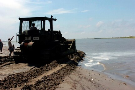 Horizontal Engineer Company, 769th Engineer Battalion, bulldoze sand to
close a strait between two peninsulas near Grand Isle, La., May 7, 2010. The closure will be a secondary defense in addition to the boom line in the Gulf of Mexico to prevent any oil from reaching further inland.