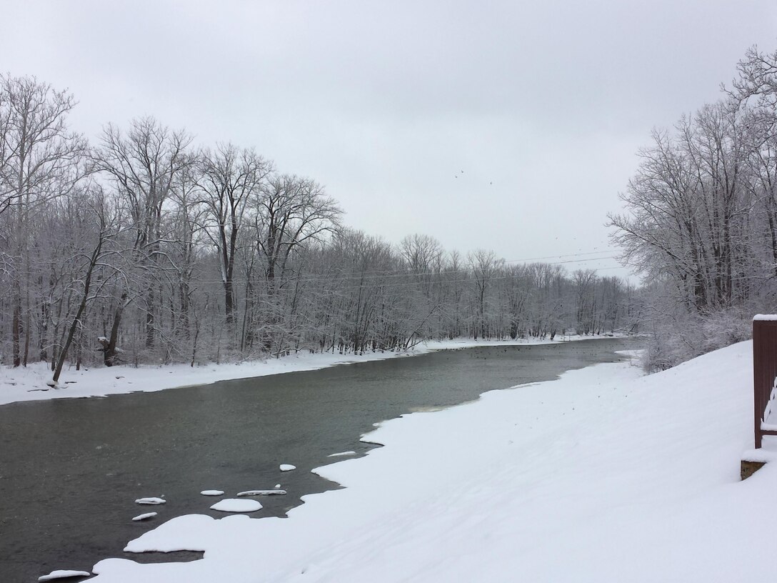 An early morning view of the tailwater at Roush Lake, Huntington, Ind. Heavy snowfall  paints the scenery as a flock of ducks enjoys the only open water around.