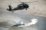 A Louisiana National Guard UH-60 Blackhawk helicopter delivers a 4,500-pound sandbag to one of five breaches along the coast of the southeast side of Lafourche Parish, May 10, 2010.