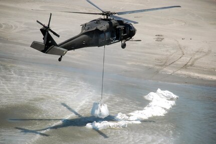 A Louisiana National Guard UH-60 Blackhawk helicopter delivers a 4,500-pound sandbag to one of five breaches along the coast of the southeast side of Lafourche Parish, May 10, 2010.