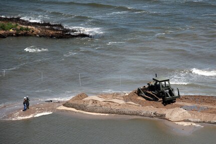 Heavy equipment operators from the Louisiana National Guard's 922nd
 Horizontal Engineer Company, 769th Engineer Battalion, bulldoze sand to
 close a strait between two peninsulas near Grand Isle, La., May 10, 2010.
 The closure will be a secondary defense in addition to the boom line in the
 Gulf of Mexico to prevent any oil from reaching further inland.