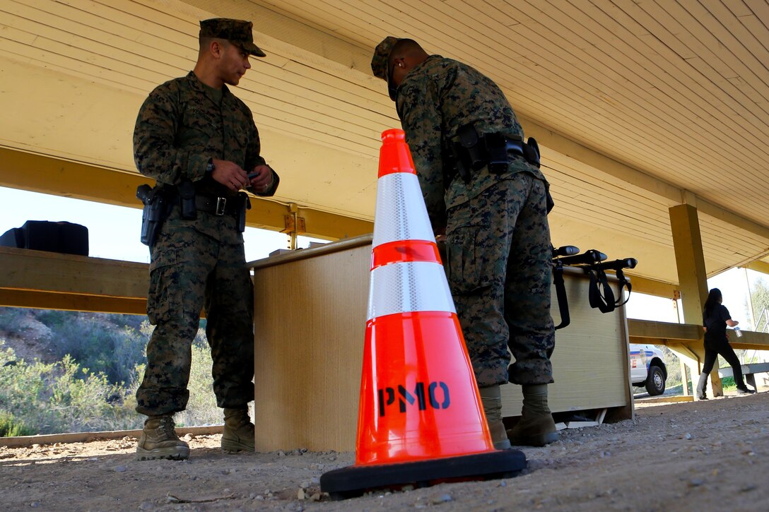 Marines with the Provost Marshals’ Office prepare their M4 tactical shotgun before firing during a practical weapons course aboard Marine Corps Air Station Miramar, Calif., Jan. 21. The training also allowed military police the opportunity to get valuable training with the M9 service pistol.