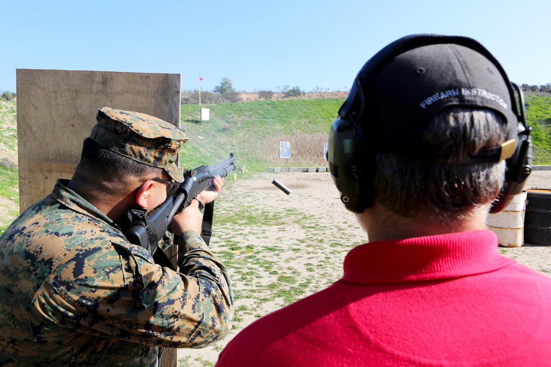 Lance Cpl. Aaron Vega, a military police officer with Headquarters and Headquarters Squadron, fires the M4 tactical shotgun behind cover while receiving instruction from Kevin Guffey, an instructor with Homeland Security Solutions, Inc., during a practical weapons course aboard Marine Corps Air Station Miramar, Calif., Jan. 21. The training allows military police the opportunity to maintain weapon proficiency in the event of an actual situation.