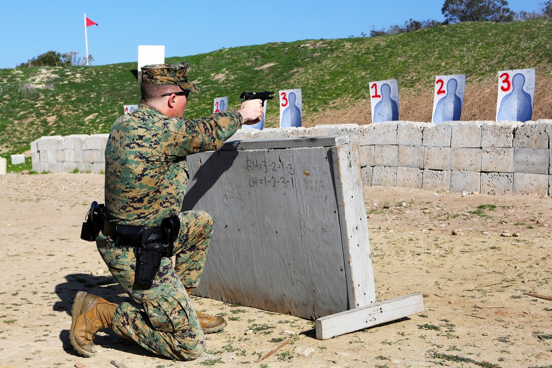 Staff Sgt. Glenn West, a chief accident investigator with Headquarters and Headquarters Squadron, fires his M9 service pistol from behind cover during a practical weapons course aboard Marine Corps Air Station Miramar, Calif., Jan. 21. The training allows military police officers to hone their skills in preparation for an actual situation.