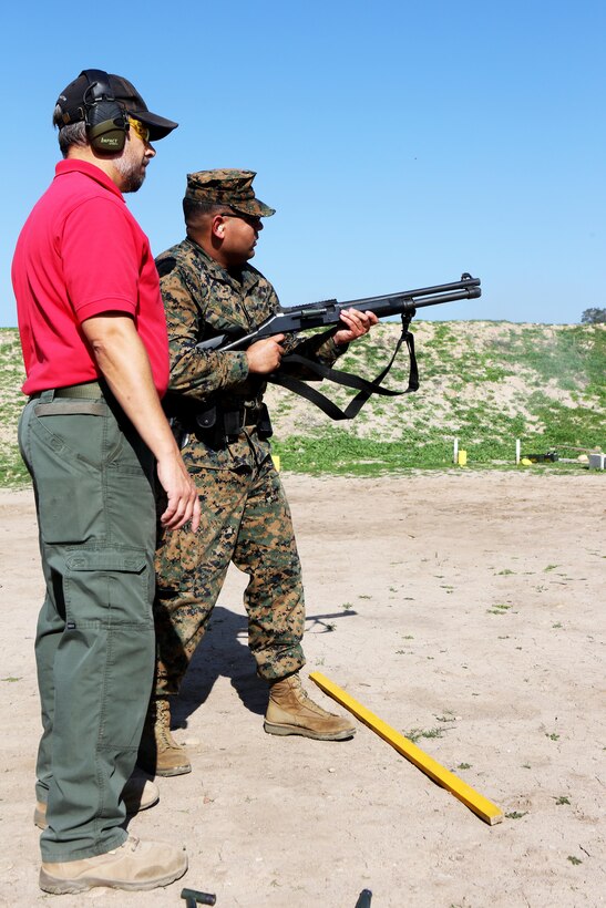 Lance Cpl. Aaron Vega, a military police officer with Headquarters and Headquarters Squadron, fires the M4 tactical shotgun from the hip as Kevin Guffey, an instructor with Homeland Security Solutions, Inc., gives course instruction during a practical weapons course aboard Marine Corps Air Station Miramar, Calif., Jan. 21.  Military police also fired the M9 service pistol to maintain weapon proficiency.