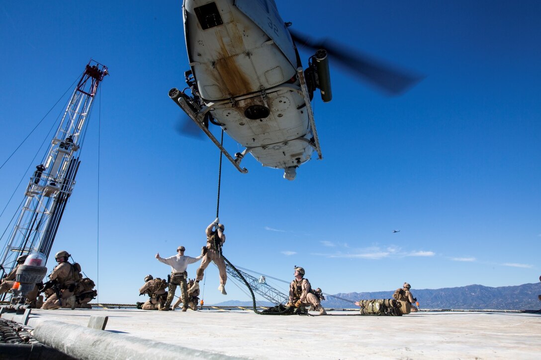 U.S. Marines with the 15th Marine Expeditionary Unit's Maritime Raid Force fast-rope onto a gas and oil platform during maritime interoperability training off the coast of Santa Barbara, Calif., Jan. 16, 2015. MIT prepares the MRF for their upcoming deployment by enhancing their combat skills and teaching them techniques for boarding vessels. (U.S. Marine Corps photo by Sgt. Jamean Berry/Released)