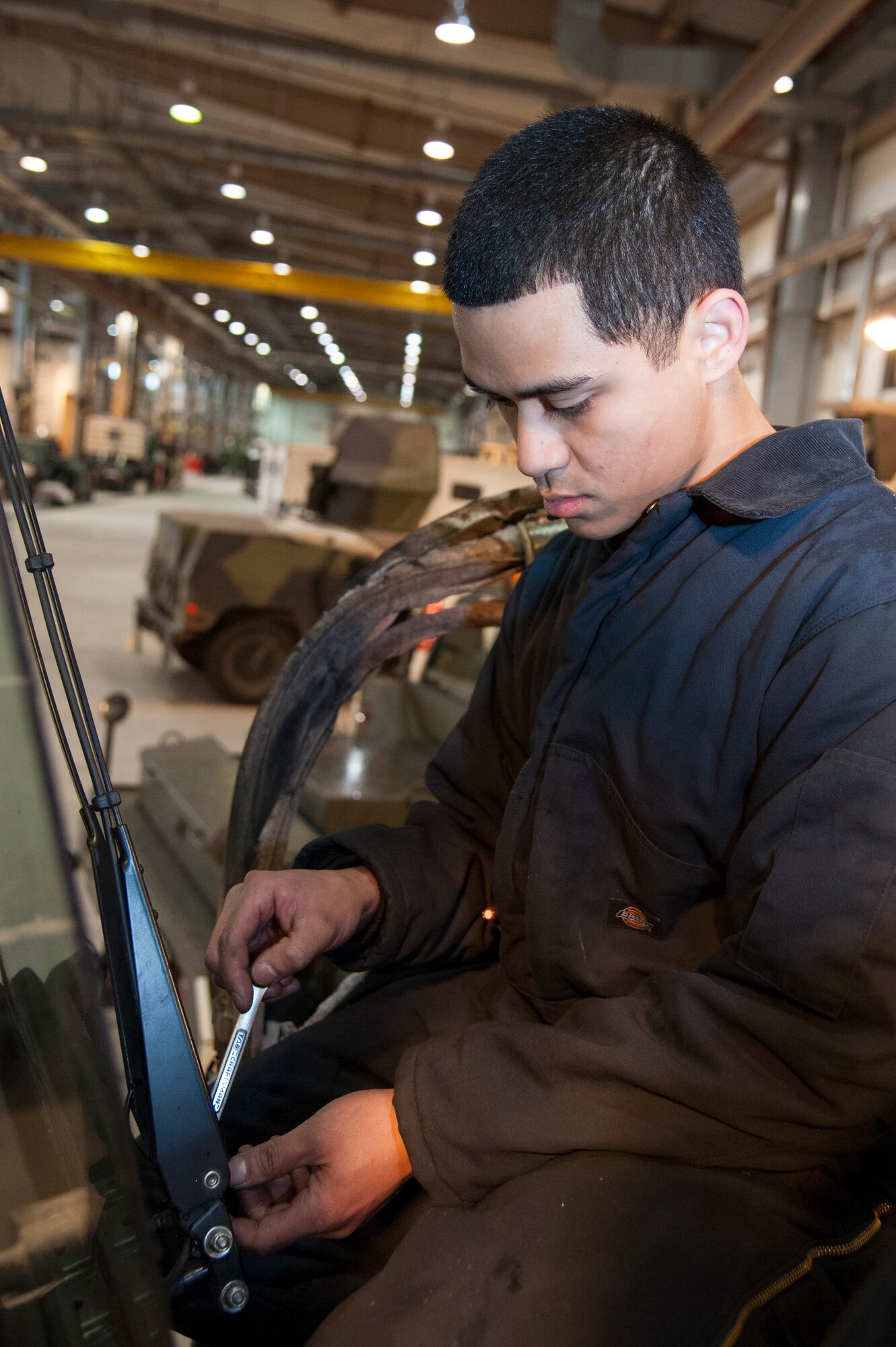 Senior Airman Gianni Sanchez, 51st Logistics Readiness Squadron vehicle mechanic, reattaches windshield wipers at Osan Air Base, Republic of Korea, Dec. 22, 2014. This type of maintenance is done by the customer service section of vehicle maintenance. (U.S. Air Force photo by Senior Airman Matthew Lancaster)