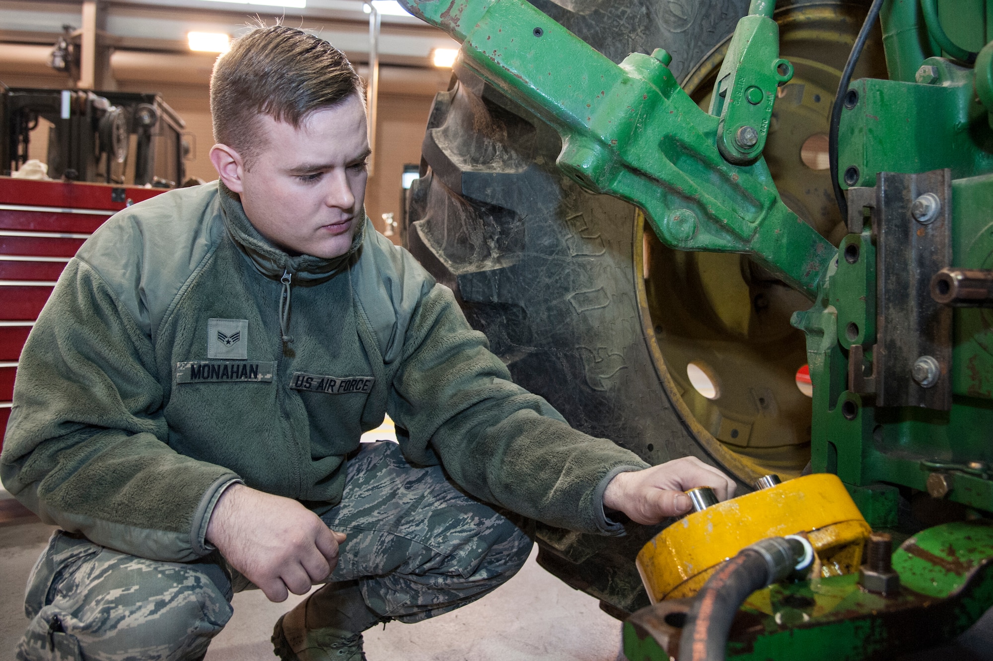 Senior Airman Martin Monahan, 51st Logistics Readiness Squadron special purpose mechanic, inspects the hydraulic pump of a kick broom street sweeper at Osan Air Base, Republic of Korea, Dec. 22, 2014. These street sweepers are used to clean the roads on Osan. (U.S. Air Force photo by Senior Airman Matthew Lancaster)