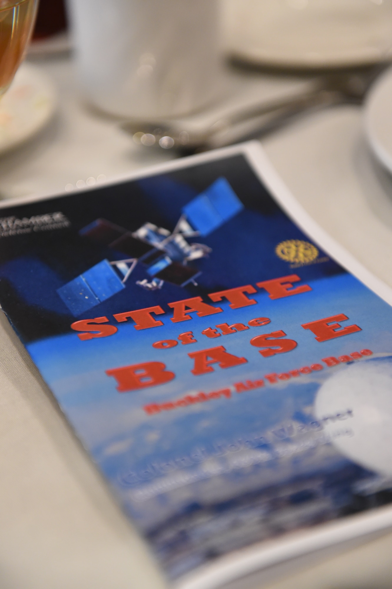 A State of the Base pamphlet is placed on a table during the State of the Base ceremony Jan. 21, 2015, at the DoubleTree by Hilton in Aurora, Colo. During the speech, Col. John Wagner, 460th Space Wing commander, discussed the base’s mission and current and upcoming events for Team Buckley, along with the base’s economic impact on the community, Aurora Rotary and Aurora Chamber of Commerce. (U.S. Air Force photo by Airman 1st Class Samantha Saulsbury/Released)
