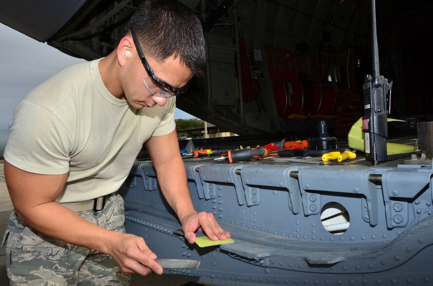 Tech Sgt. Michael Rutherford, a maintenance crew member with the 403rd Fabrication Flight, works to custom-make a sheet metal patch to repair a puncture wound on a 815th Airlift Squadron C-130J ramp door on the Keesler Air Force Base flightline. (U.S. Air Force Photo/Master Sgt. Brian Lamar)