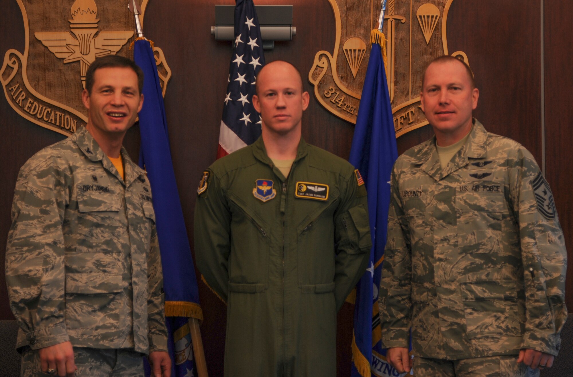 Col. James Dryjanski, 314th Airlift Wing commander, and Chief Master Sgt. Brian LaBounty, 314th AW command chief, congratulate Tech. Sgt. Jason Burnham, 314th Operations Group Tactics noncommissioned officer in charge, and a 48th Airlift Squadron C-130J fuselage training unit instructor Jan. 22, 2015, at Little Rock Air Force Base, Ark. Burnham, a Paskenta, Calif., native, led response teams in investigating more than 20 airdrop malfunctions. (U.S. Air Force photo by Airman 1st Class Harry Brexel) 