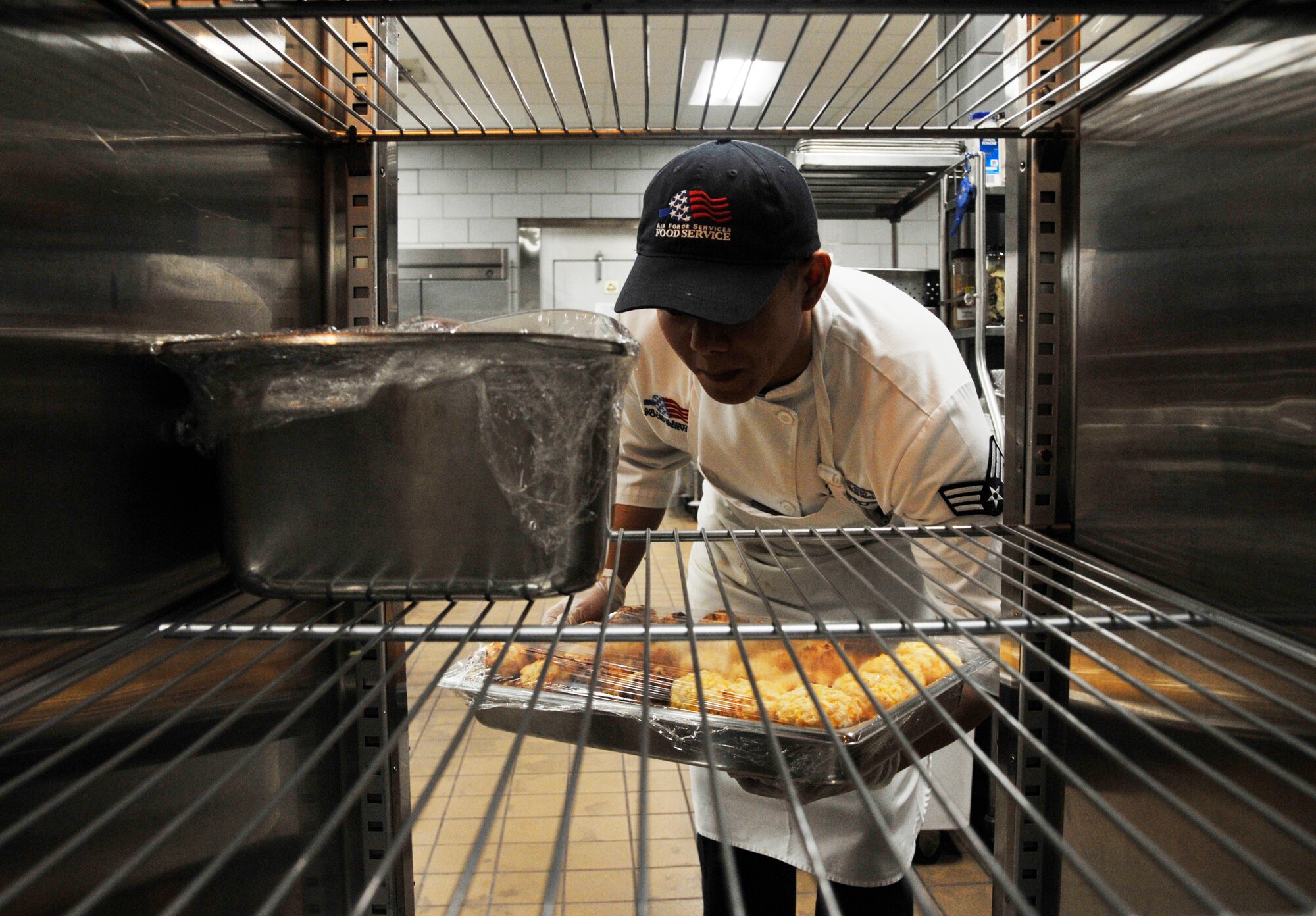 U.S. Air Force Senior Airman Marco Tordera, 509th Force Support Squadron food service journeyman, organizes the warmer at Whiteman Air Force Base, Mo., Jan. 21, 2015. The Ozark Inn team dining facility team is preparing to be evaluated for the John L. Hennessy Award inspection. Each year the Air Force presents the John L. Hennessy Award to recognize the team who best excels in food service. (U.S. Air Force photo by Senior Airman Keenan Berry/Released)