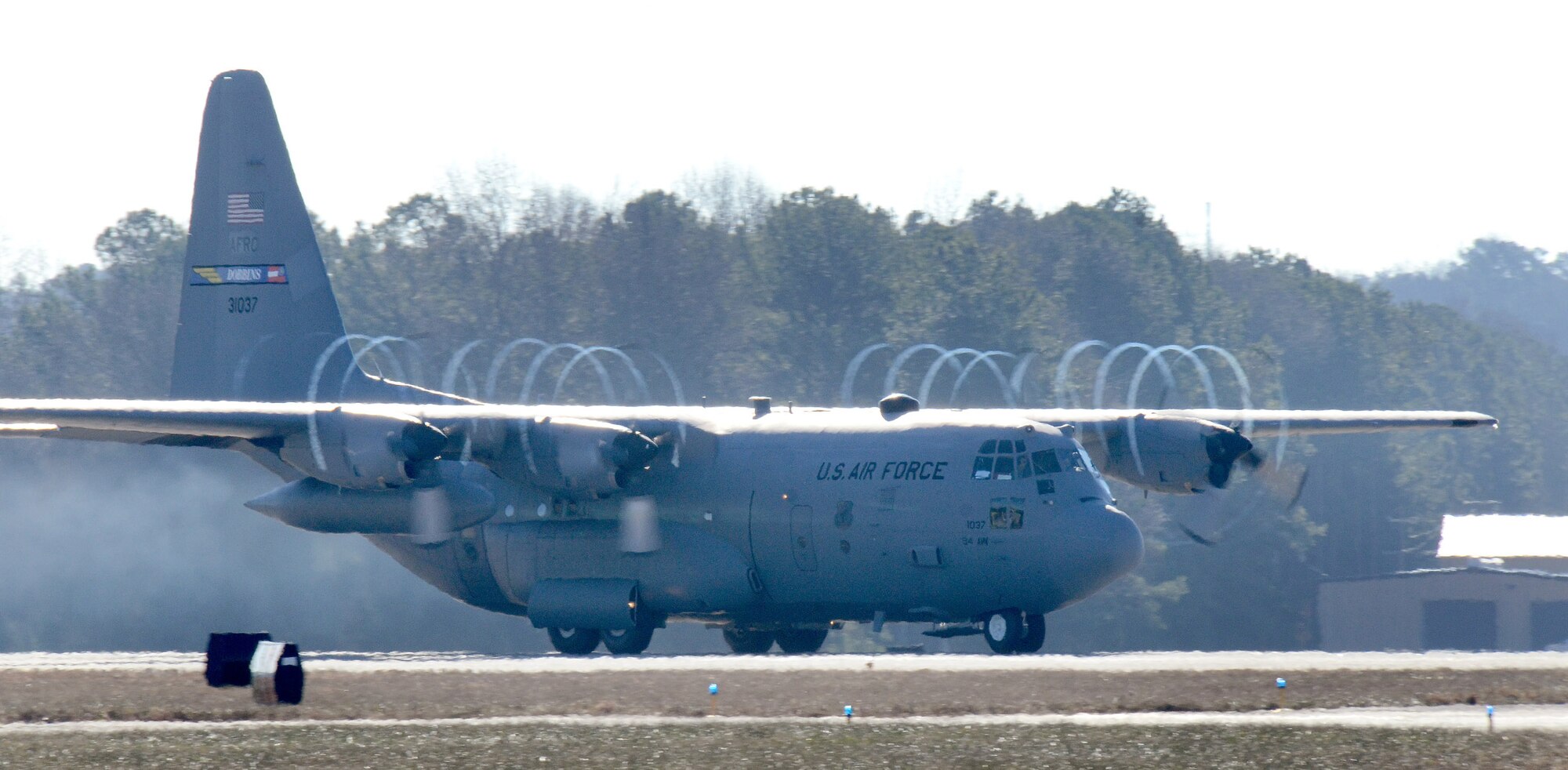 The 94th Airlift Wing C-130H3 beats the moisture out of the air as it accelerates down the Dobbins runway on its way to Southwest Asia; Dobbins Air Reserve Base, Ga., Jan. 8, 2015. (U.S. Air Force photo/Brad Fallin)