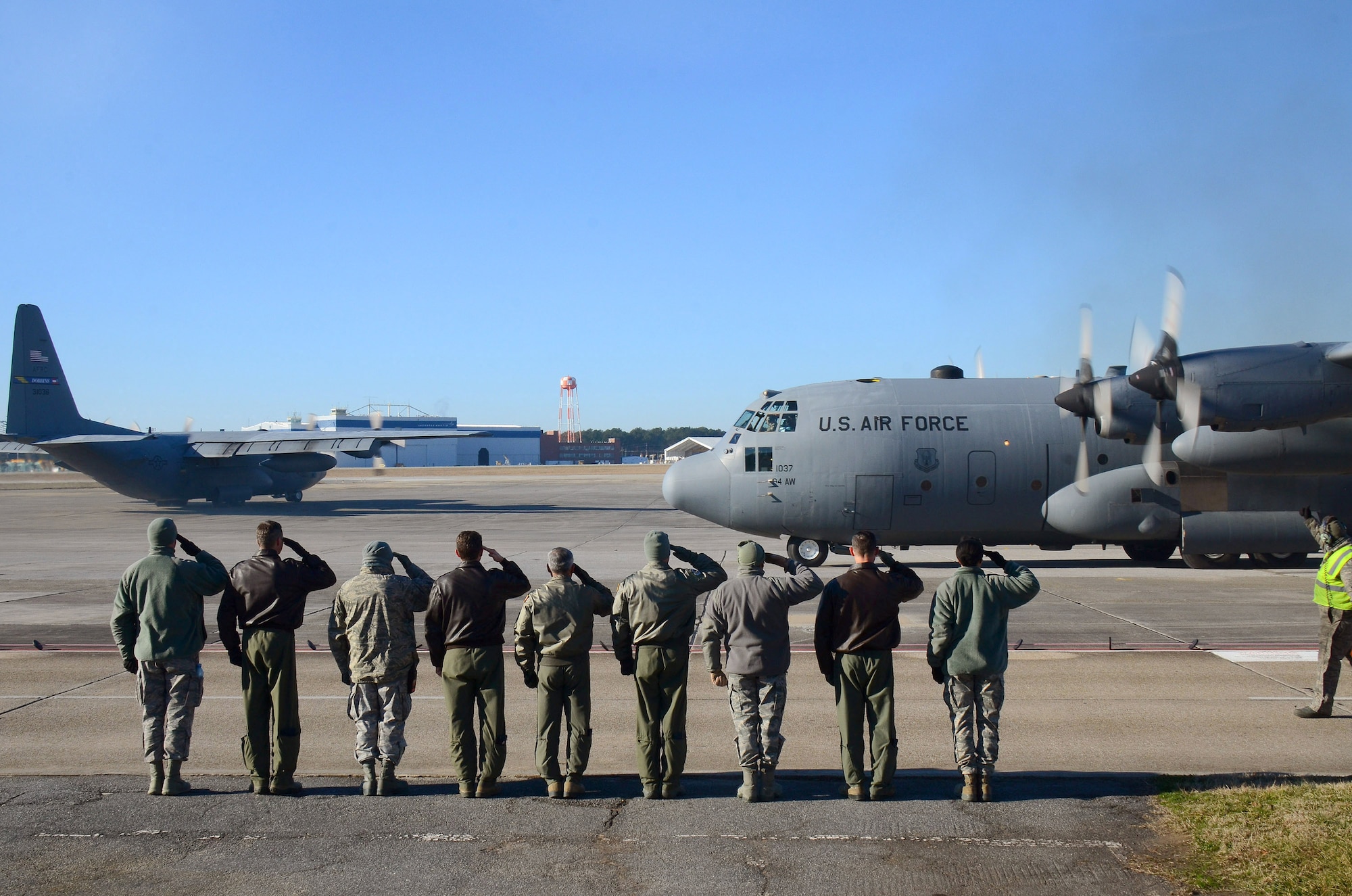 Dobbins Air Reserve Base leadership salutes the second aircrew as the 94th Airlift Wing Hercules begins to taxi out for takeoff to Southwest Asia, at Dobbins Air Reserve Base, Ga., Jan. 8, 2015. (U.S. Air Force photo/Brad Fallin)