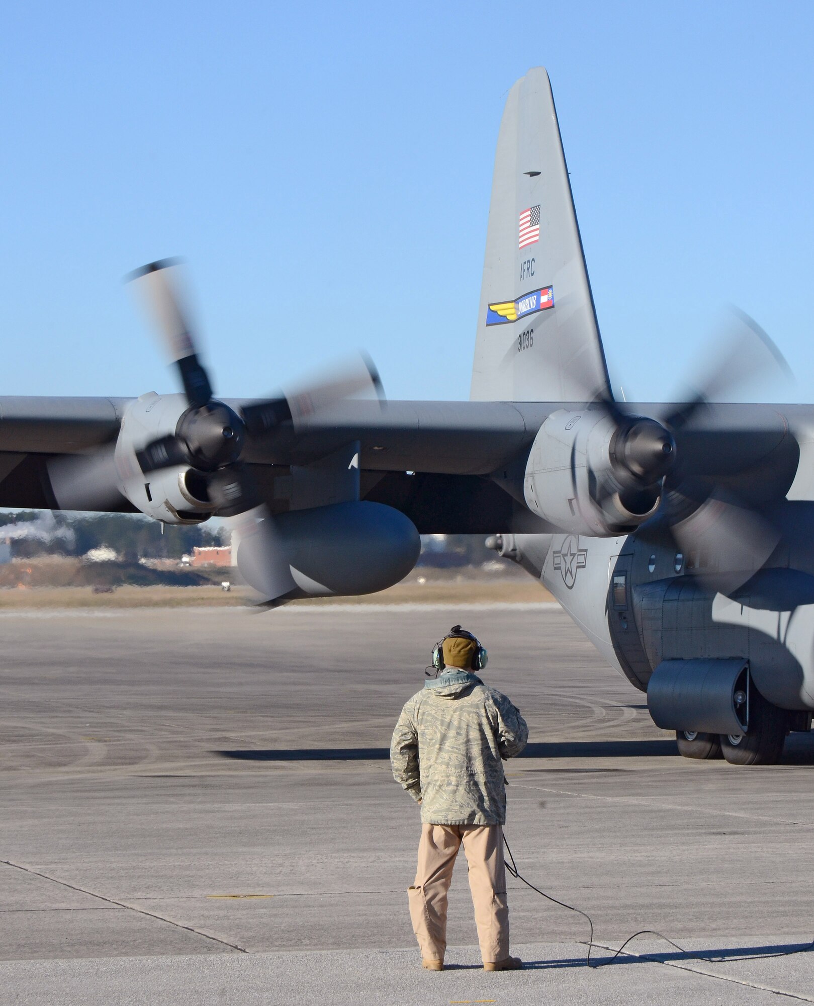 A 700th Airlift Squadron loadmaster monitors engines start for the C-130H aircraft. The aircraft and crew are leaving for deployment to Southwest Asia, Jan. 8, 2015 at Dobbins Air Reserve Base, Ga.  (U.S. Air Force photo/Brad Fallin)