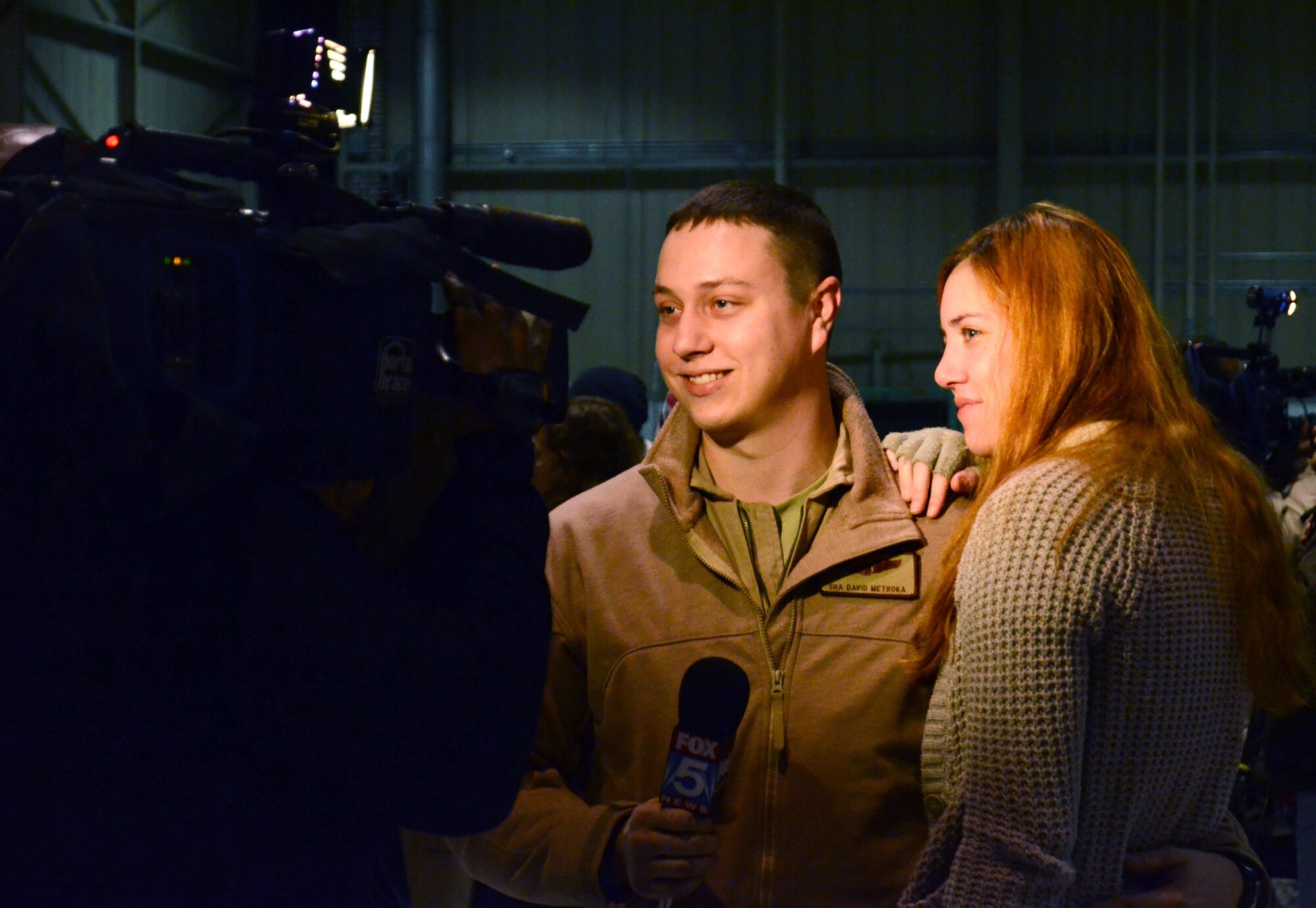 Senior Airman David Metroka is interviewed with his wife by Fox 5 news at the deployment send-off, Jan. 8, 2015 at Dobbins Air Reserve Base, Ga. (U.S. Air Force photo/Brad Fallin)