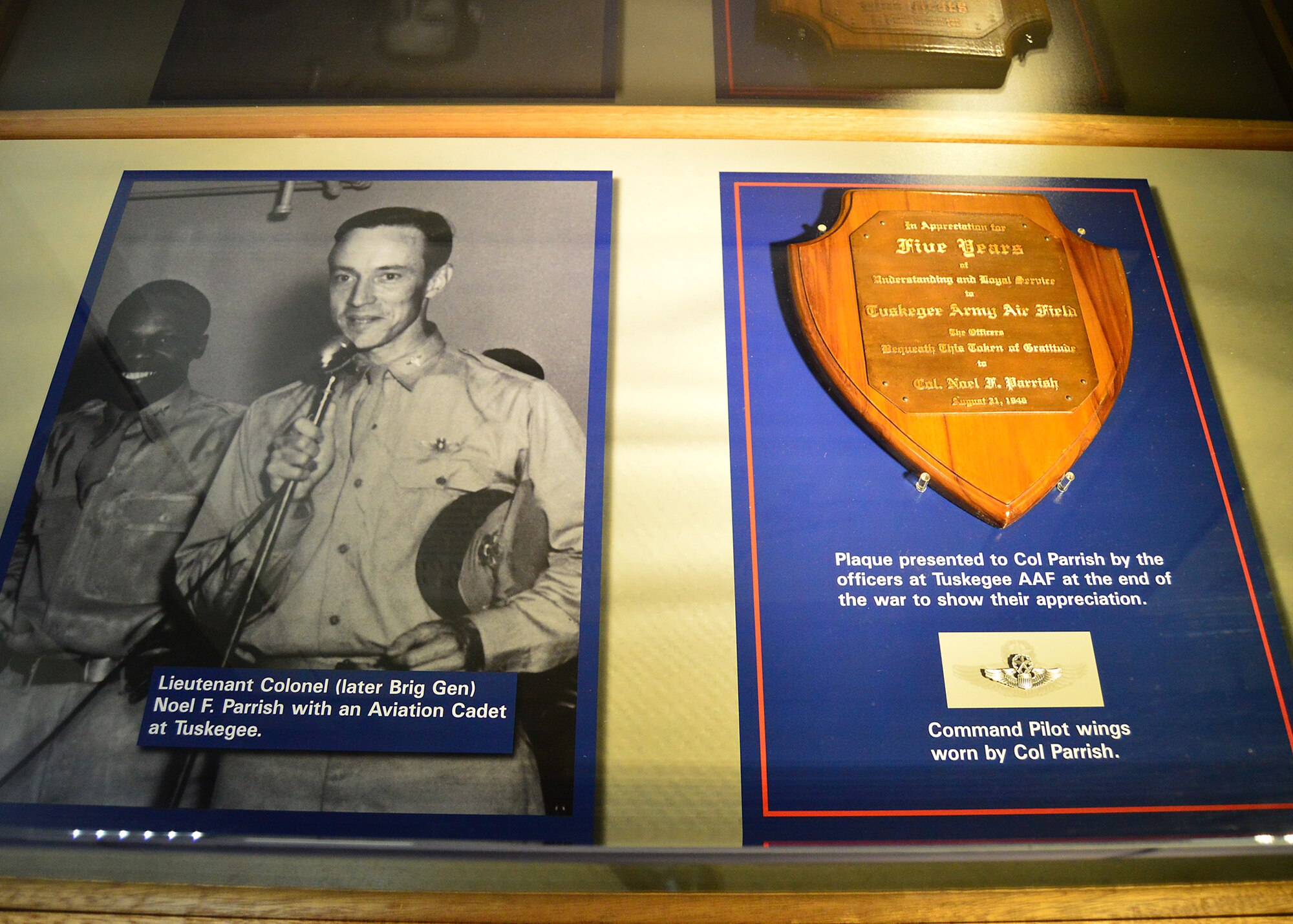 DAYTON, Ohio -- Lieutenant Colonel (later Brig Gen) Noel F. Parrish with an Aviation Cadet at Tuskegee. Also on display are his Command Pilot wings, and a plaque presented to Col Parrish by the officers at Tuskegee AAF at the end of the war to show their appreciation. This display is located in the Tuskegee Airmen Exhibit in the WWII Gallery at the National Museum of the U.S. Air Force. (U.S. Air Force photo)