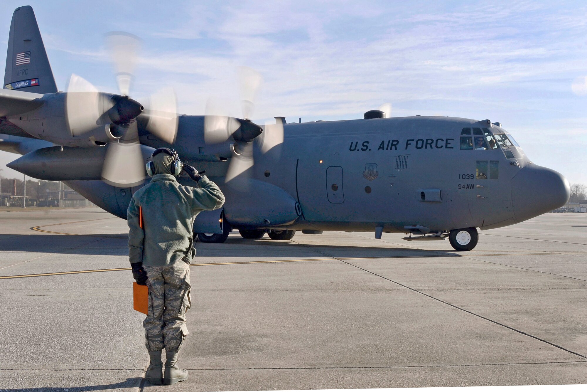 The view Don Peek, 94th Airlift Wing photographer, captures as crew chief, Senior Airman David Yancey salutes the aircrew as they take his aircraft to Southwest Asia; Dobbins Air Reserve Base, Ga., Jan. 5, 2015. (U.S. Air Force photo/Don Peek)