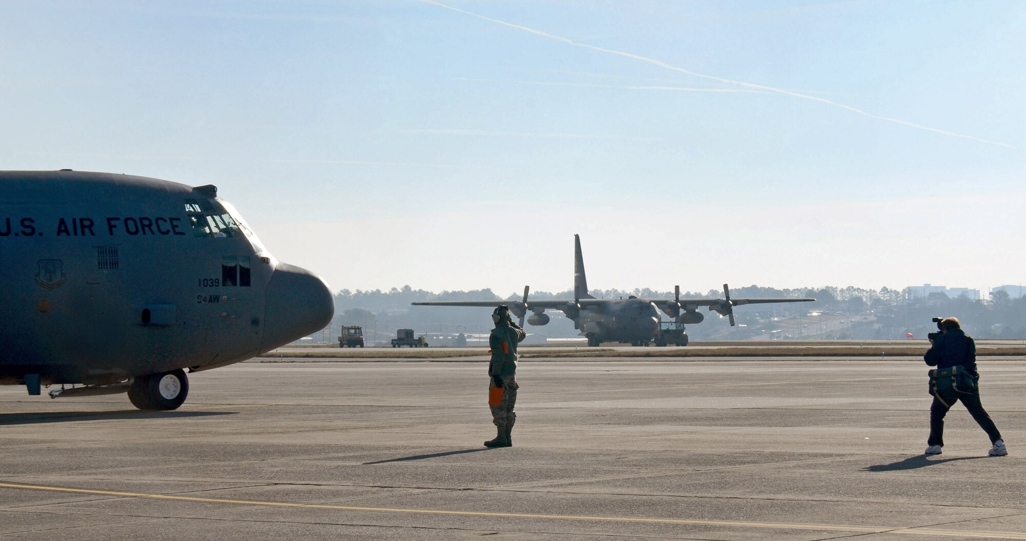Don Peek, 94th Airlift Wing photographer, captures crew chief, Senior Airman David Yancey saluting the aircrew as they take his aircraft to Southwest Asia; Dobbins Air Reserve Base, Ga., Jan. 5, 2015. (U.S. Air Force photo/Brad Fallin)