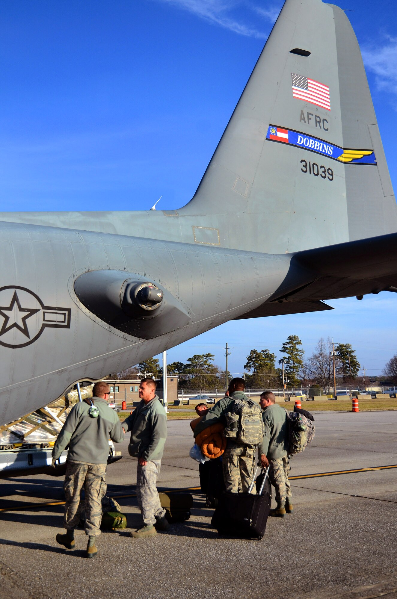 Deploying members of the 94th Airlift Wing bring their personal bags to the back of the C-130H for loading prior to takeoff for their Southwest Asia deployment, Jan. 5, 2015 at Dobbins Air Reserve Base, Ga.  (U.S. Air Force photo/Brad Fallin)