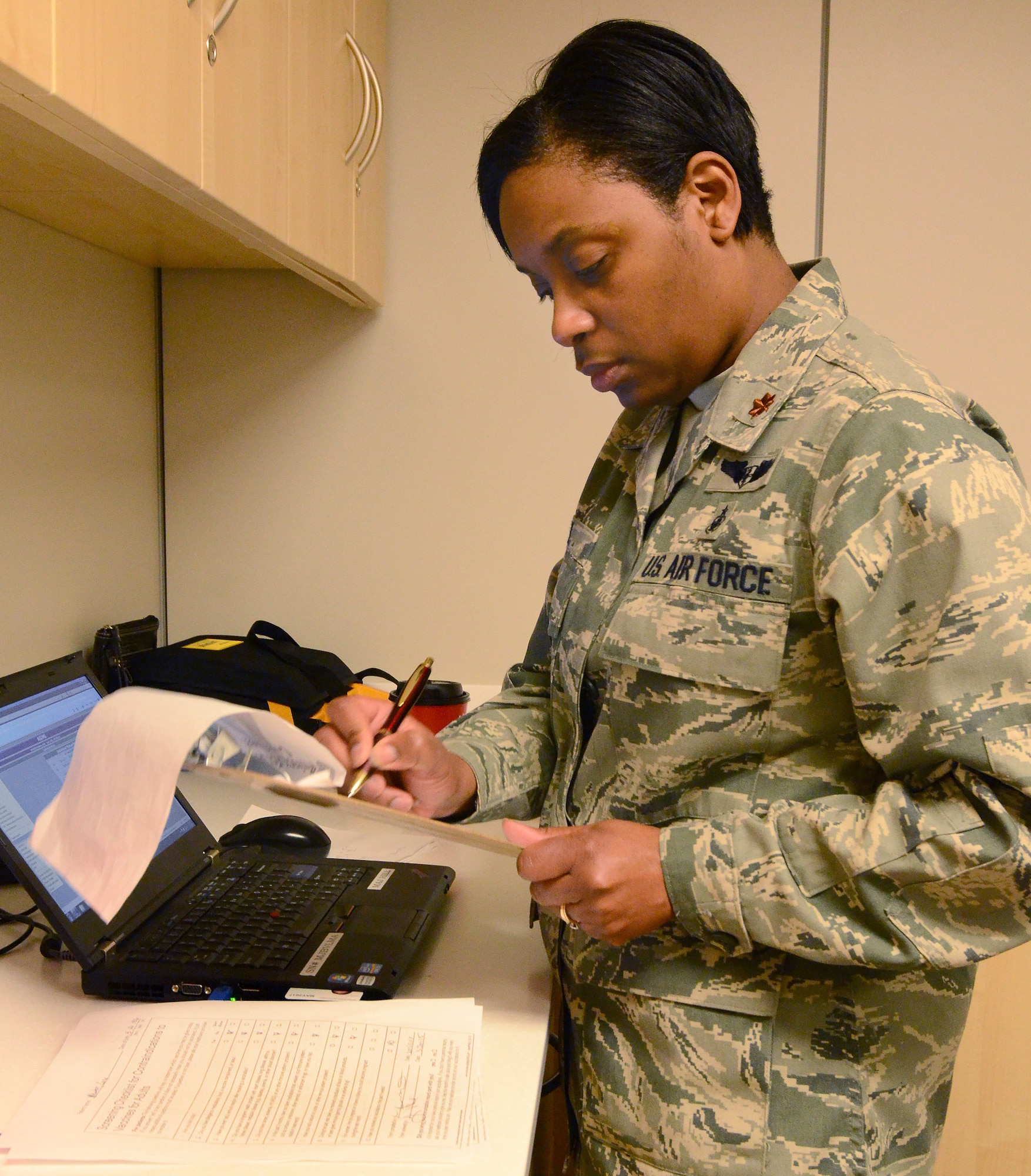 Maj. Sylena Hill reviews immunization records of deploying personnel to ensure all information is correct and shots are up to date for their deployment to Southwest Asia; Dobbins Air Reserve Base, Ga., Jan. 2, 2015. (U.S. Air Force photo/Brad Fallin)
