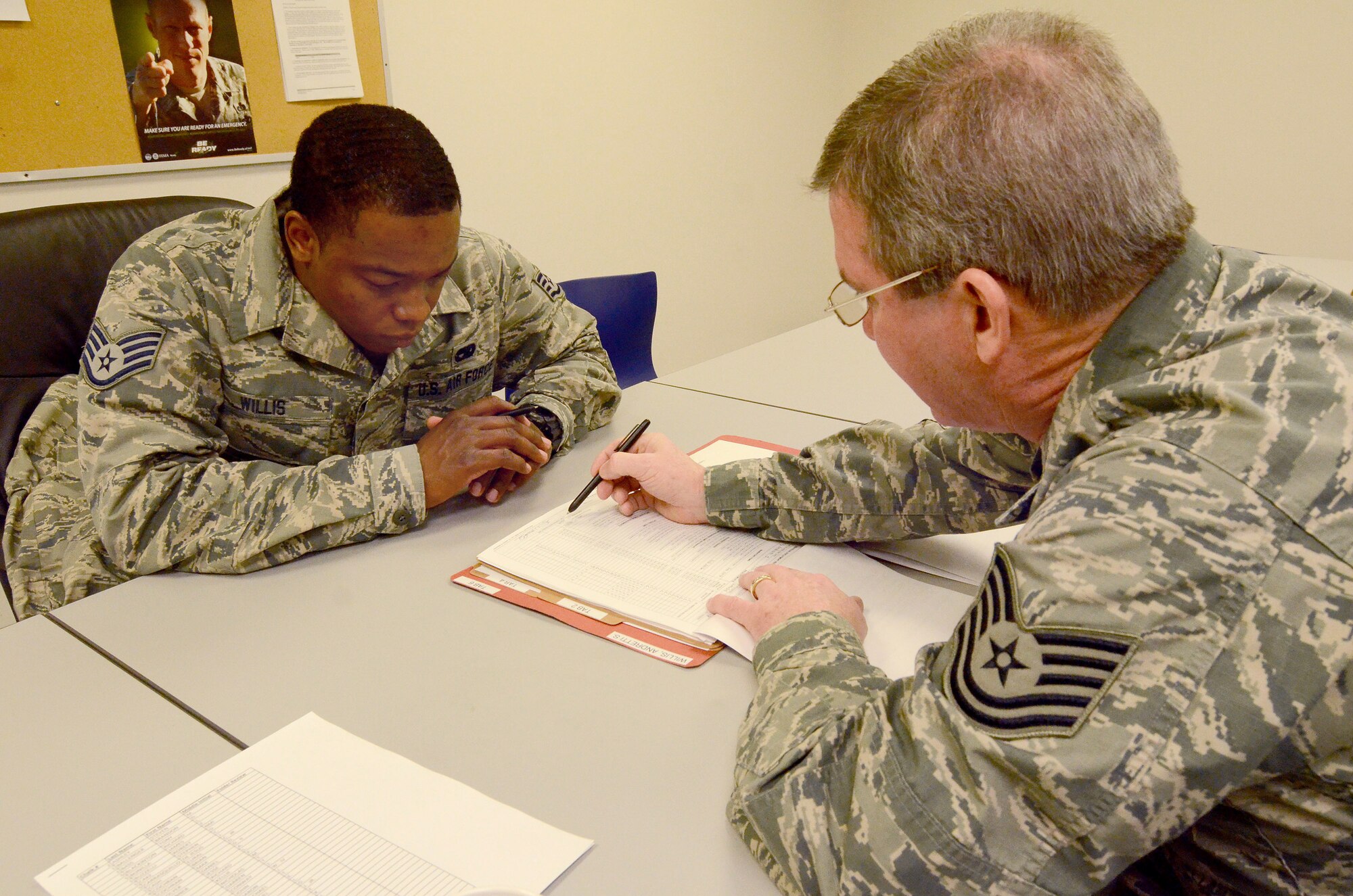 Staff Sgt. Andretti Willis reviews his mobility folder with Tech. Sgt. Alan McKibben, to ensure all information is correct and up to date for his deployment to Southwest Asia; Dobbins Air Reserve Base, Ga., Jan. 2, 2015. (U.S. Air Force photo/Brad Fallin)