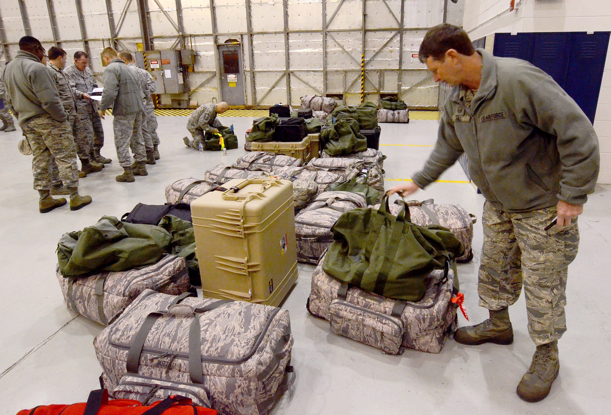 Master Sgt. Francis Hill adds his mobility bags to the growing line-up of deployment baggage being gathered from members of the 94th Airlift Wing in preparation for their up-coming Southwest Asia deployment, Jan. 2, 2015 at Dobbins Air Reserve Base, Ga.  (U.S. Air Force photo/Brad Fallin)