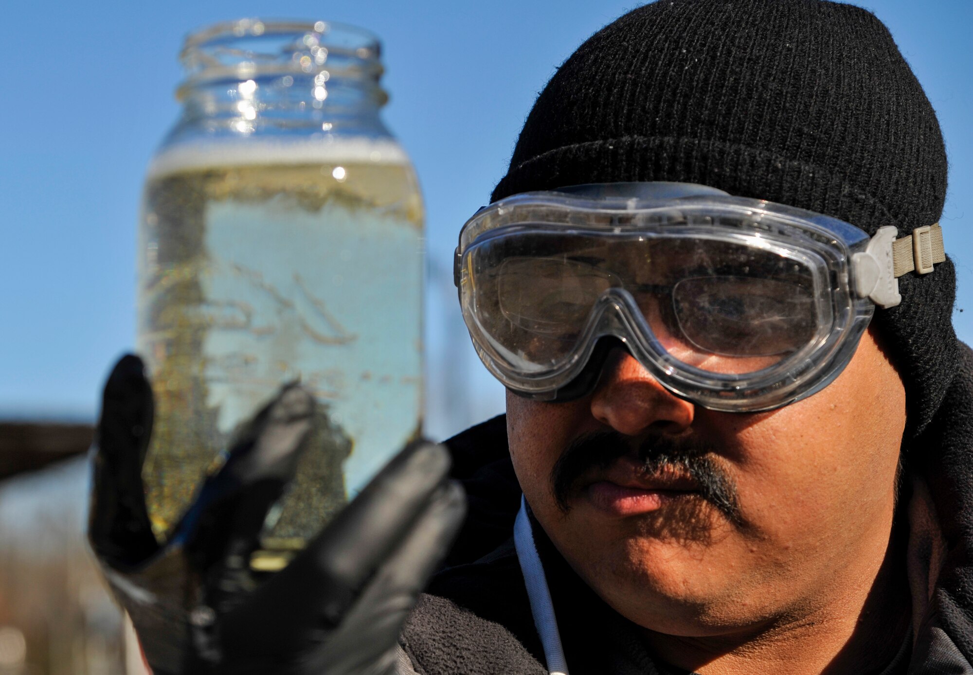 Erick Ruiz Herrera, a 19th Logistics Readiness Squadron bulk fuels distribution mechanic, inspects a glass jar filled with a sample of jet fuel Jan. 5, 2015, at Little Rock Air Force Base, Ark. Fuel is routinely drained from pipelines at The Rock to ensure they do not contain water or ice. (U.S. Air Force photo by Airman 1st Class Harry Brexel)