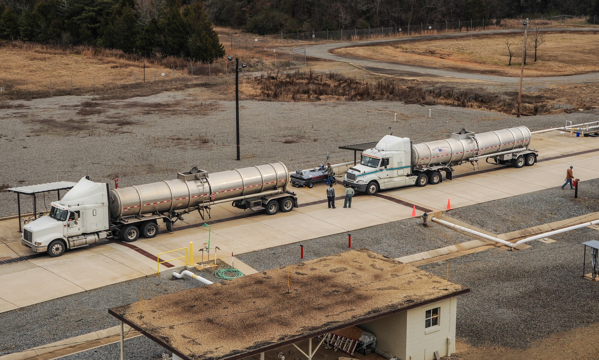 Two truck drivers wait as fuel from their trucks is emptied by bulk fuels terminal technicians Dec. 18, 2014, at Little Rock Air Force Base, Ark. The amount of jet fuel needed each week varies, depending on mission requirements. (U.S. Air Force photo by Airman 1st Class Harry Brexel) 