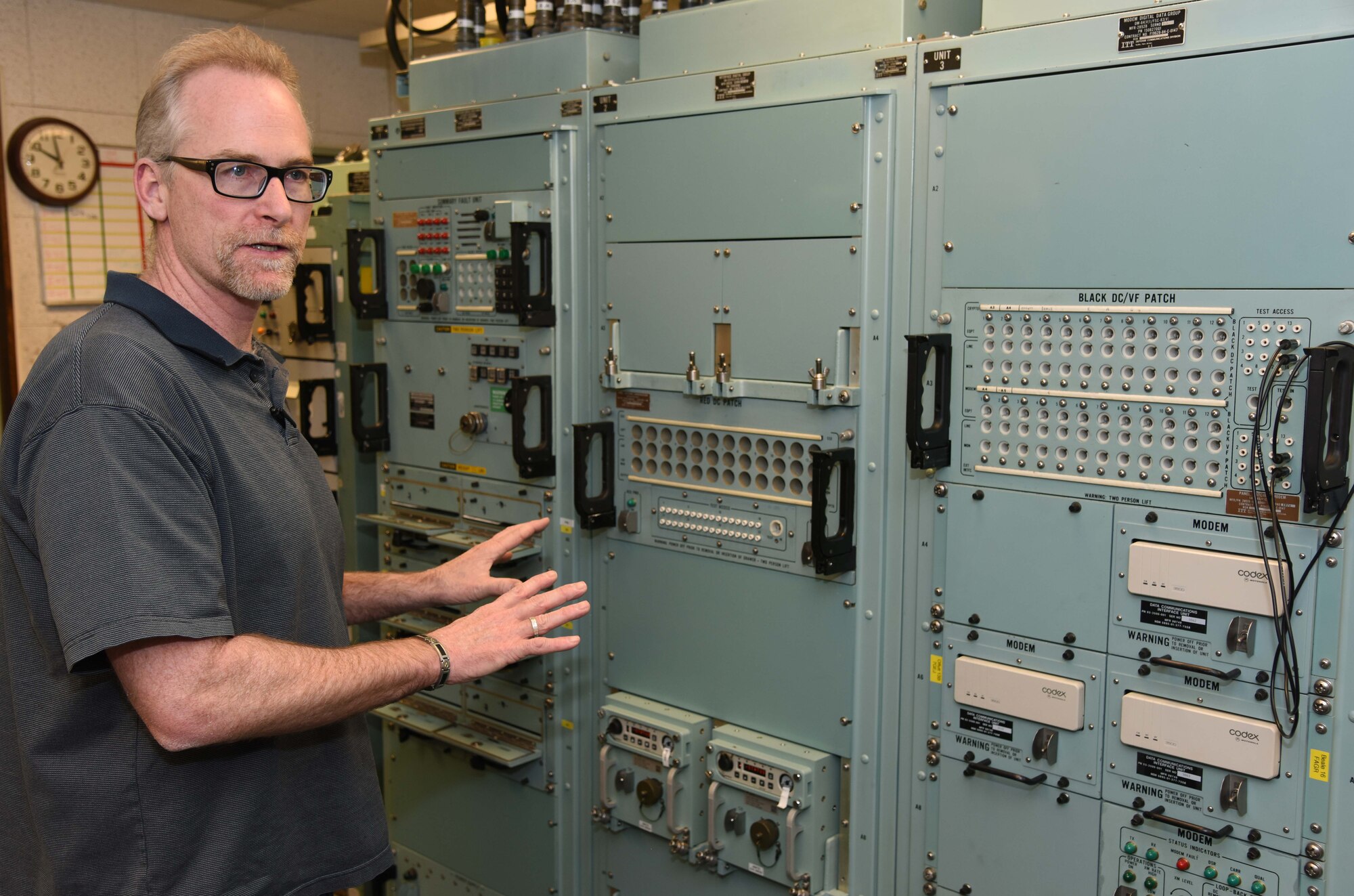 Bob Fick, 341st Missile Maintenance Squadron missile satellite instructor, explains the functions of communications equipment in a launch control center trainer at Malmstrom Air Force Base, Mont., Jan. 20, 2015. Fick uses the trainer to familiarize 341st MMXS Airmen with how they will work in the missile field. (U.S. Air Force photo/Airman 1st Class Dillon Johnston)