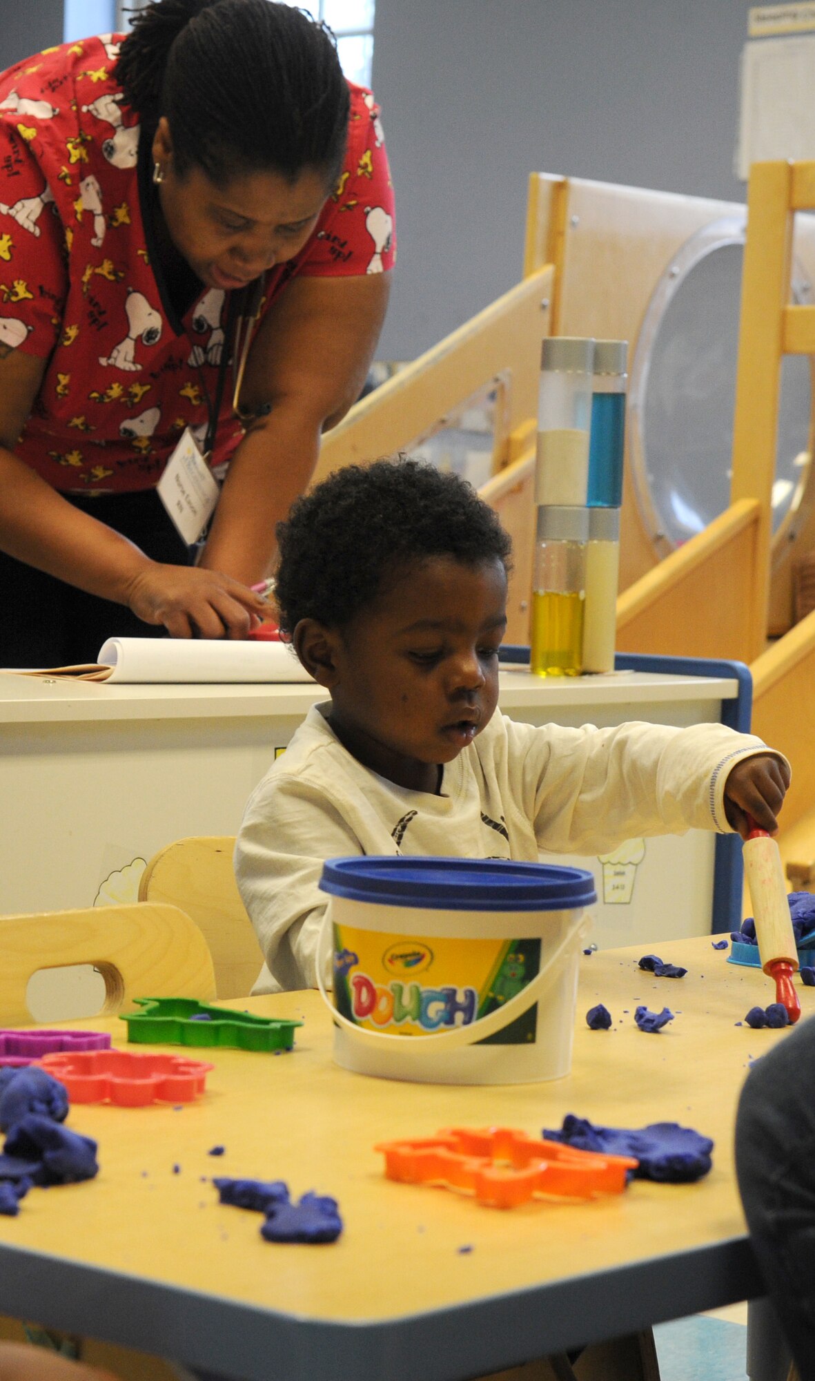 A staff member documents daily activities as a child plays at Bright Beginnings, Inc. a child care centers in the District of Columbia that offer free care to homeless infants and preschoolers. The Joint Base Andrews B.A.S.E. 5/6 council created a partnership with Bright Beginnings coordinating bi-monthly opportunities for Airmen to volunteer at the center. In addition, the council also coordinates donation drives to benefit the center. (U.S. Air Force photo/Master Sgt. Tammie Moore)