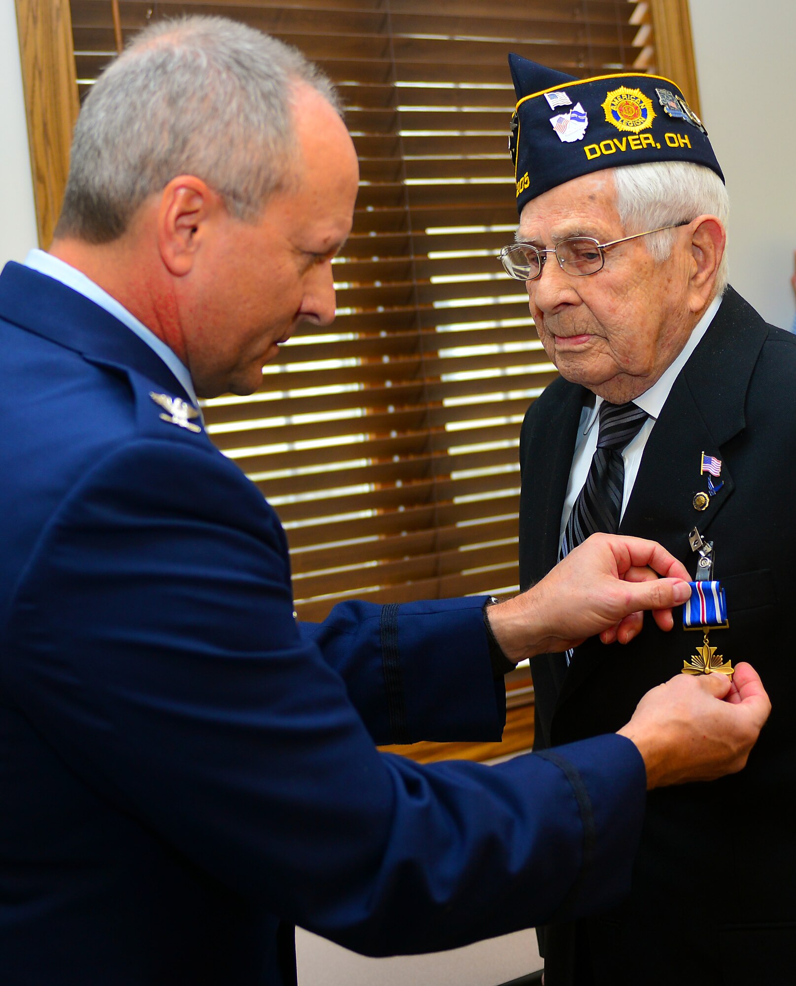 U.S. Air Force Col. Jim Jones, 121st Air Refueling Wing Commander, presents retired Staff Sgt. Jesse Reese with the Distinguished Flying Cross medal Jan. 16, 2015, in Dover, Ohio. Reese earned the medal on Dec. 31, 1944,  as a tail gunner over the skies of Hamburg, Germany. (U.S. Air National Guard photo by Master Sgt. Ralph Branson/Released)
