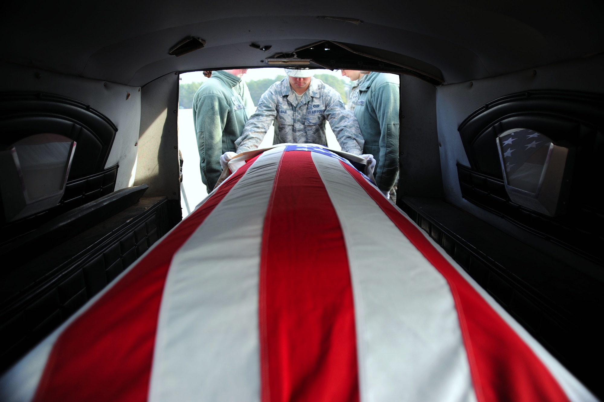 U.S. Air Force Airmen assigned to the 20th Force Support Squadron honor guard train for funeral ceremonies by removing a training casket from a hearse at Shaw Air Force Base, S.C., Jan. 22, 2015. The Airmen were recently assigned to the honor guard and will have approximately two weeks of training before they can perform a ceremony. (U.S. Air Force photo by Airman 1st Class Michael Cossaboom/Released)