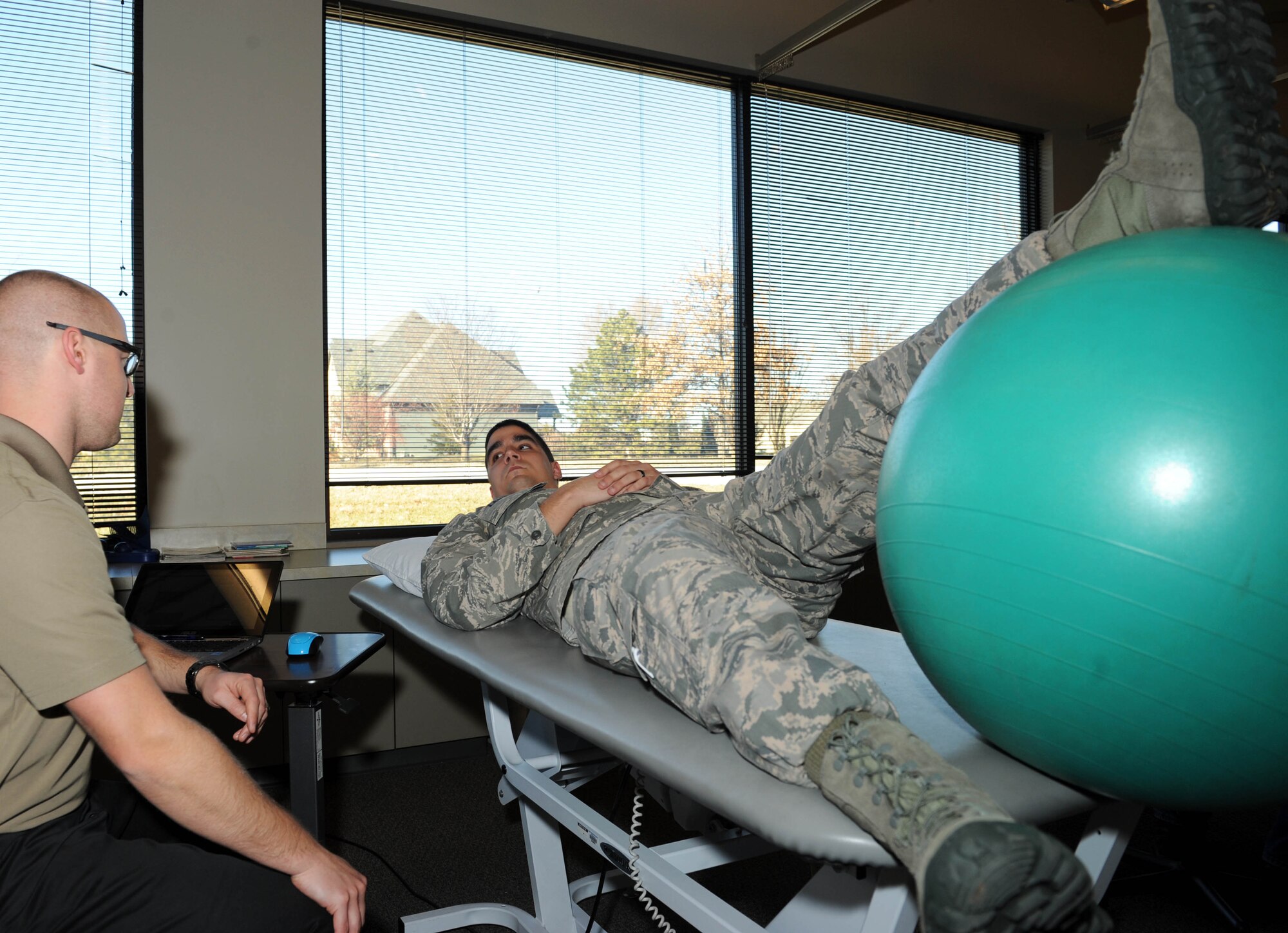 Airman 1st Class Jeffrey Langford, 22nd Security Forces Squadron elite guardsman, listens to Zane Ochs, his physical therapist, during a session, Jan. 15, in Wichita, Kan. Langford tore several ligaments in his knee during an intramural football game and is going through rehab to gain full active status. (U.S. Air Force photo/Airman 1st Class David Bernal Del Agua)