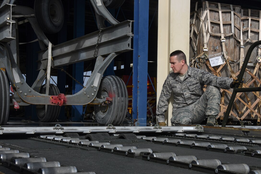 Tech. Sgt. Geoff Monsour, 32nd Aerial Port Squadron ramp operations specialist, watches a piece of cargo as he transfers it onto a loading dock from a 60-thousand pound loader while training at Travis Air Force Base, Calif., Jan. 19. If cargo isn’t correctly placed on the loader or the loader isn’t correctly lined up with the loading dock equipment may become damaged or get stuck while being transferred. (U.S. Air Force photo by Senior Airman Joshua J. Seybert)