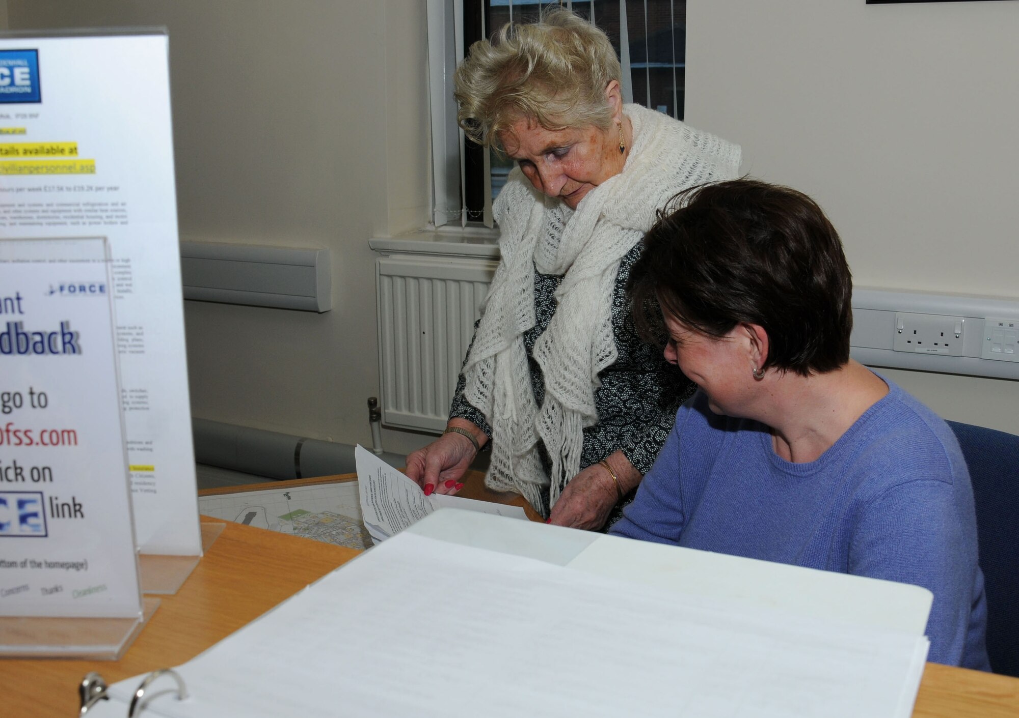 Patricia Hall, left, 100th Force Support Squadron Civilian Personnel Office advisor to the civilian personnel officer from Feltwell, Norfolk, and Karen Robson, 100th FSS Human Resources assistant from Butzbach, Germany, discuss recent policy review Dec. 31, 2014 on RAF Mildenhall, England. Hall advises the civilian personnel officer, and resolves employee complaints, grievances, disciplinary actions, supervisors training, management and assistance visits. (U.S. Air Force photo by Gina Randall/Released)