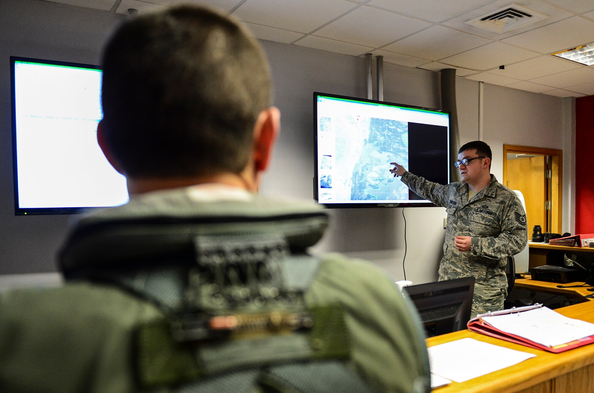Tech. Sgt. Matthew Renkosiak, 48th Operation Support Squadron NCO in charge of mission integration function, briefs the most up-to-date weather intelligence to pilots before they fly their training mission for the day from Royal Air Force Lakenheath, England, Jan. 22, 2015. Renkosiak was nominated for a Liberty Spotlight because he embodies the core values of Service Before Self and Excellence In All We Do. (U.S. Air Force photo by Airman 1st Class Erin R. Babis/Released)