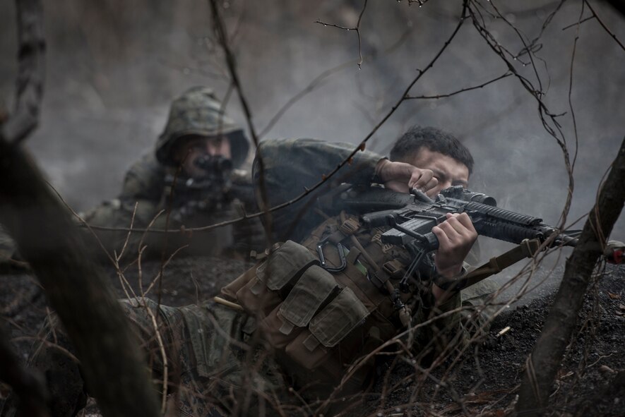 A Marine with the 1st Batallion, 1st Marines, pulls the firing bolt on his weapon while in a simulated small-arms fire exchange at Camp Fuji, Japan, Jan. 16, 2015. The Marines, who were acting as enemy aggressors searching for Air Force aircrew during survival, evasion, resistance and escape training, also practiced their small arms engagement with a “rescue” team of Marines. (U.S. Air Force photo by Staff Sgt. Cody H. Ramirez/Released)