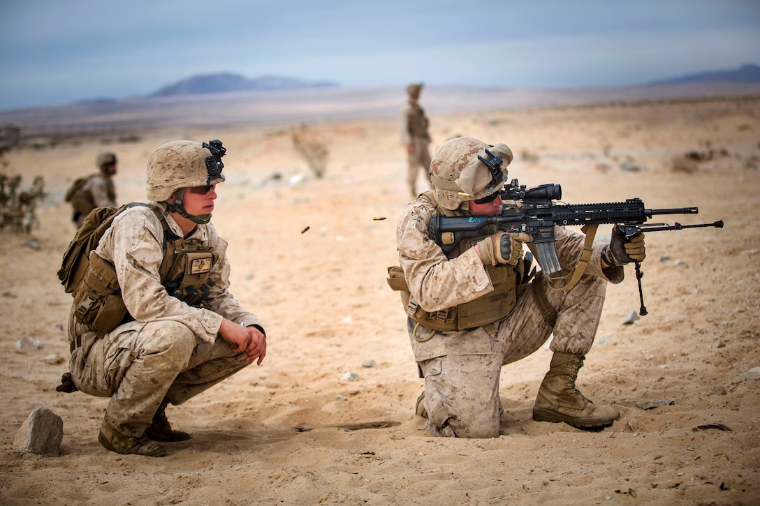 Navy Petty Officer 3rd Class Jordan A. Kopf, right, fires the M27 ...