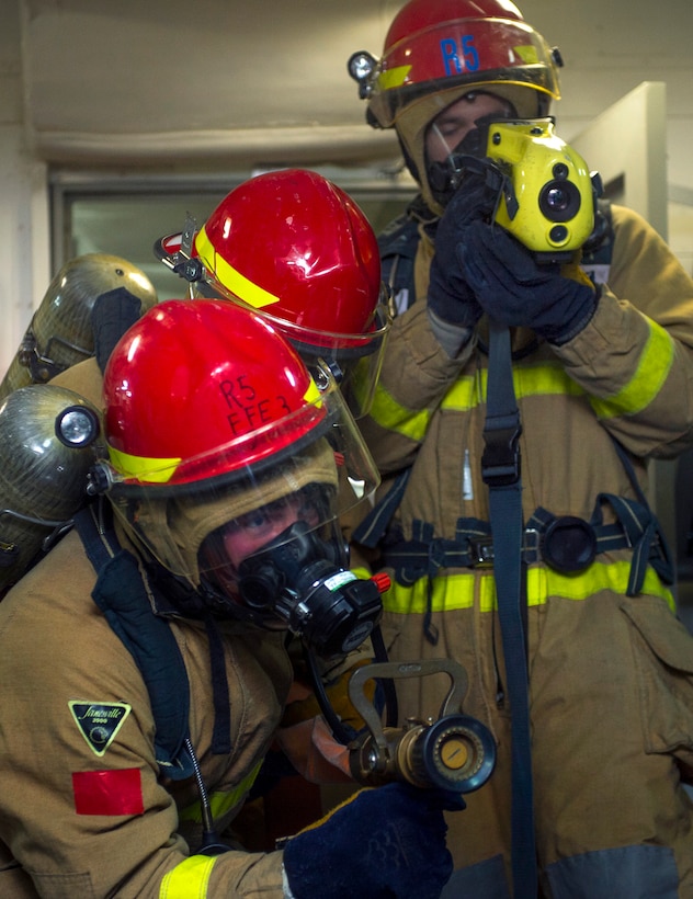 U.S. sailors fight a simulated fire during a general quarters drill ...