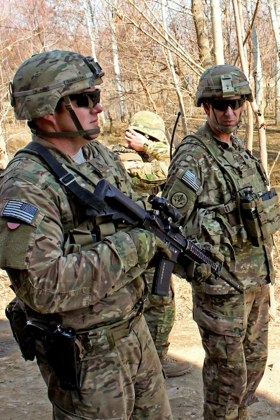 U.S. Army Staff Sgt. Douglas Edmiston, left, provides security while U ...
