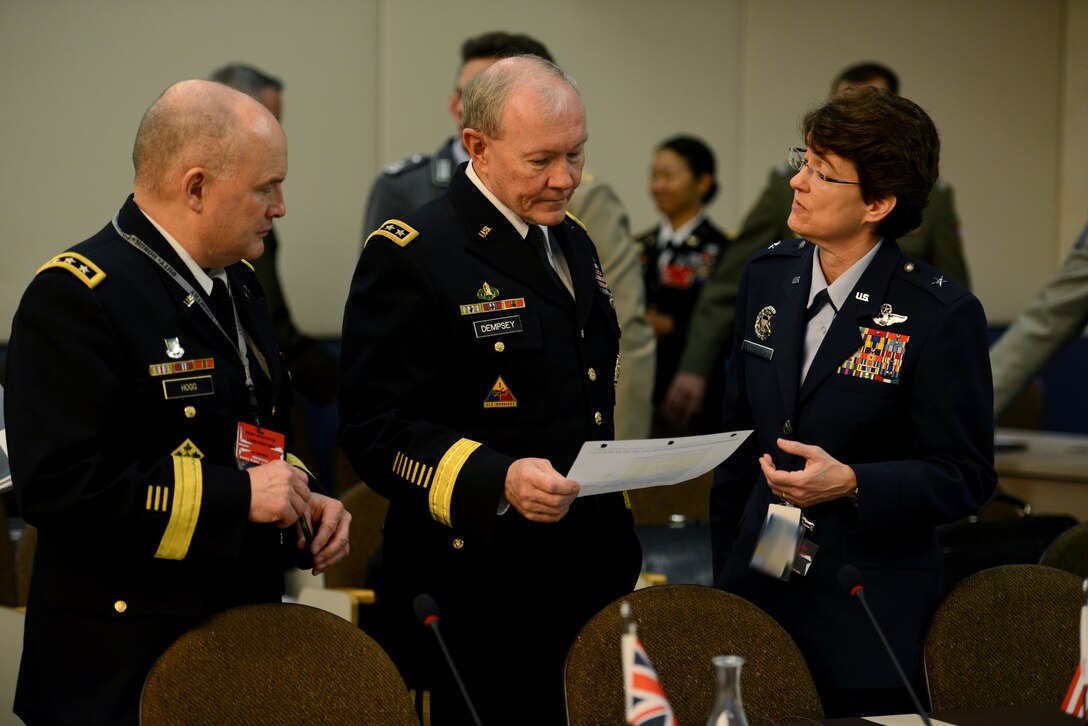 U.S. Army Gen. Martin E. Dempsey, center, chairman of the Joint Chiefs of Staff, receives a brief from U.S. Air Force Brig. Gen. Jacqueline Van Ovost, deputy director for Joint Staff politico-military affairs for Europe, NATO, Russia, during the NATO military committee and chiefes of defense meetings in Brussels, Jan. 22, 2015. 