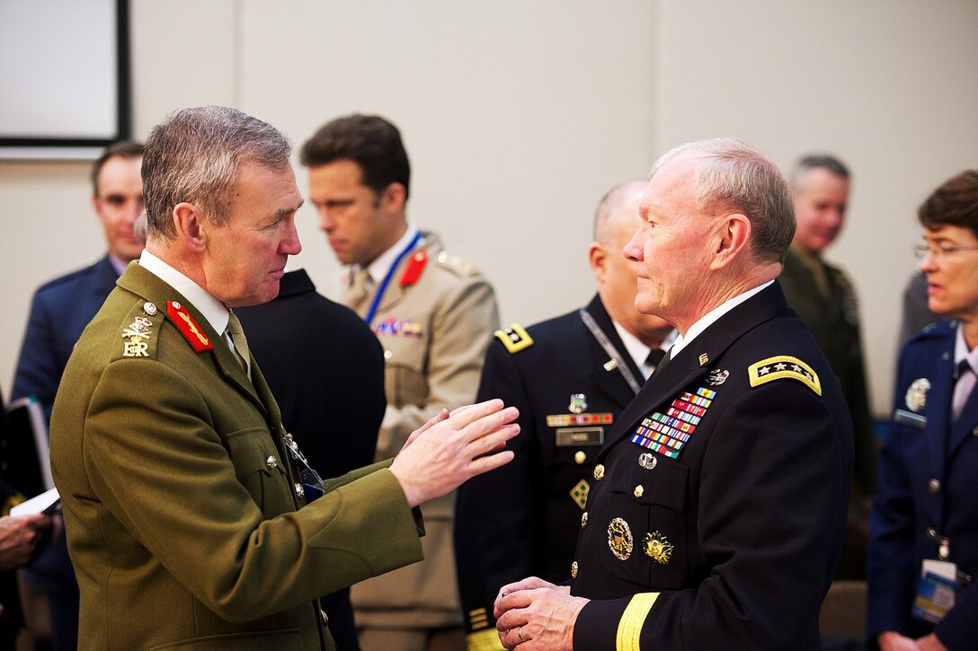 U.S. Army Gen. Martin E. Dempsey, chairman of the Joint Chiefs of Staff, talks with British Army Gen. Nicholas Houghton, chief of Britain's defense staff, during NATO’s Military Committee meetings in Brussels, Jan. 22, 2015. 